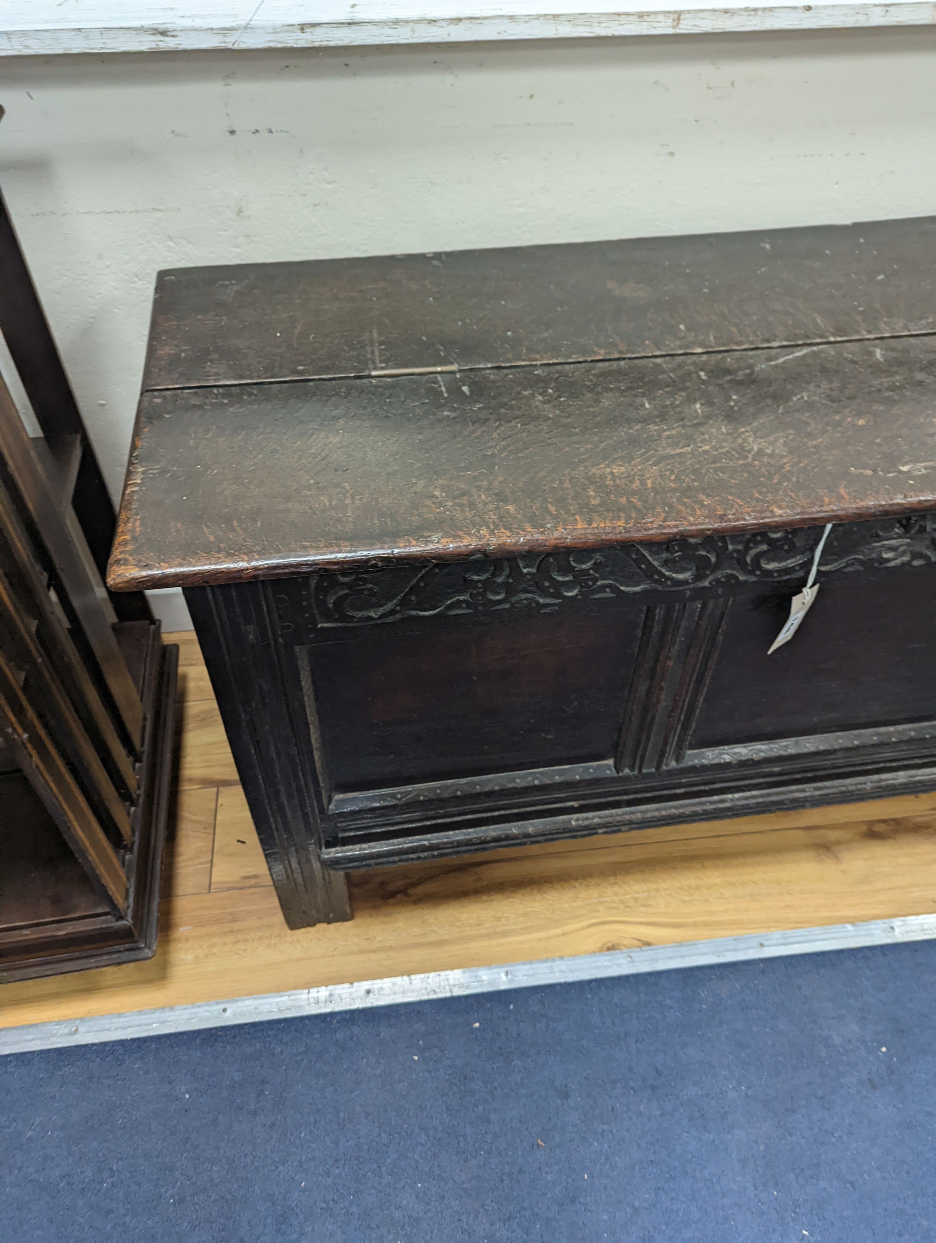 A 17th century panelled oak coffer, (the hinged lid adapted) width 130cm, depth 49cm, height 63cm